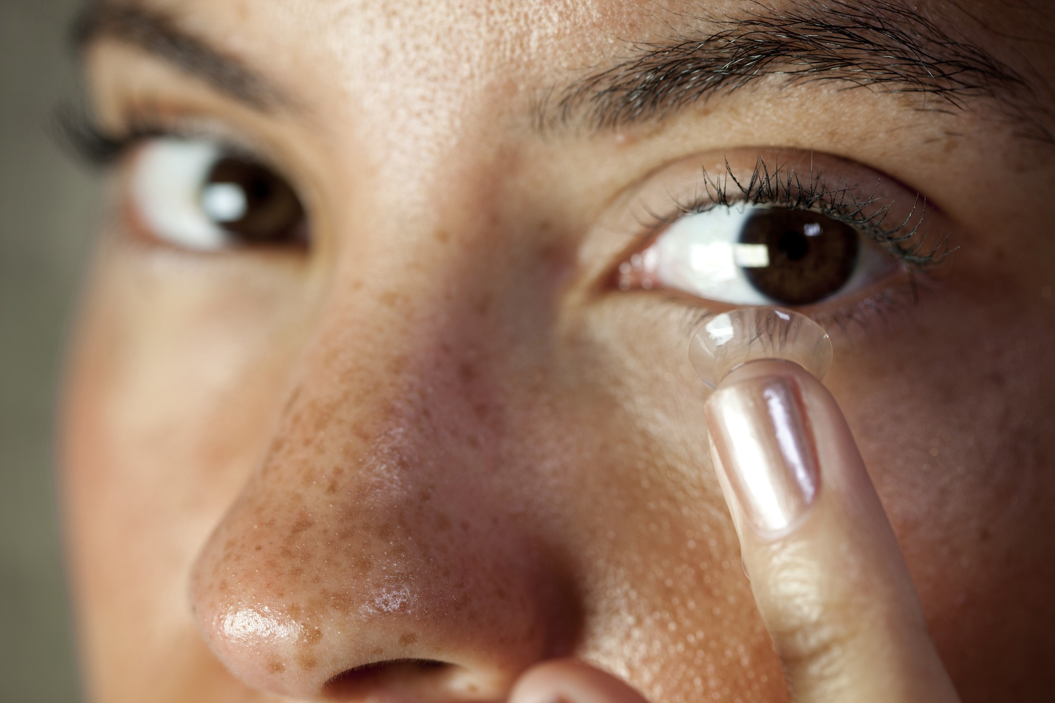 A woman inserts a contact lens.